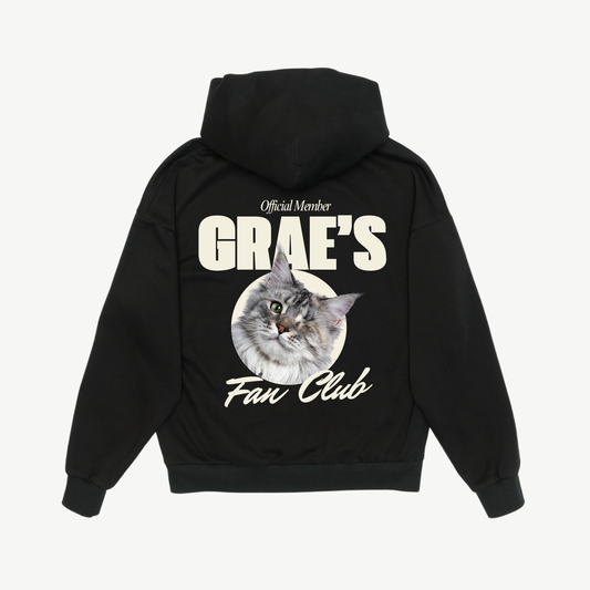 Back of a black Fan Club hoodie with a grey cat portrait and cream lettering.