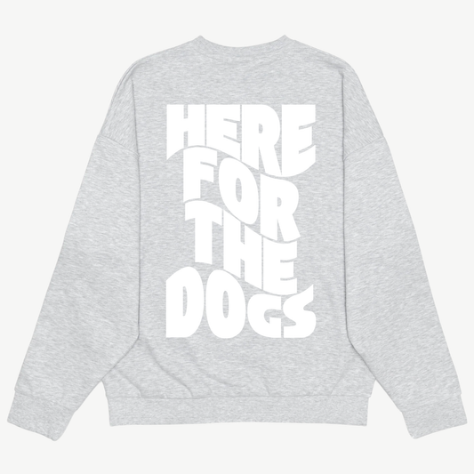 Back of a light grey crewneck with large white “Here for the Dogs” lettering stacked vertically.