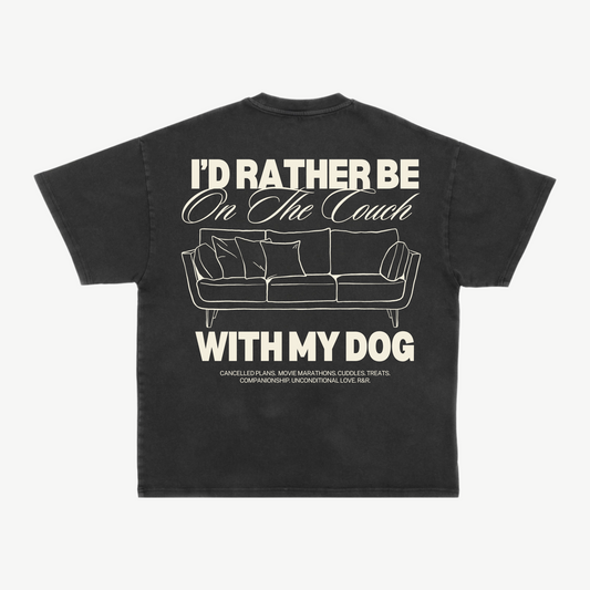 Back of a black tee with a cream couch illustration and “I’d rather be on the couch with my dog” lettering.