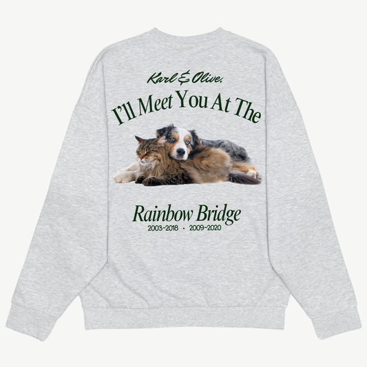 Back of a light grey crewneck with a dog and cat portrait and green “I’ll meet you at the Rainbow Bridge” memorial lettering.