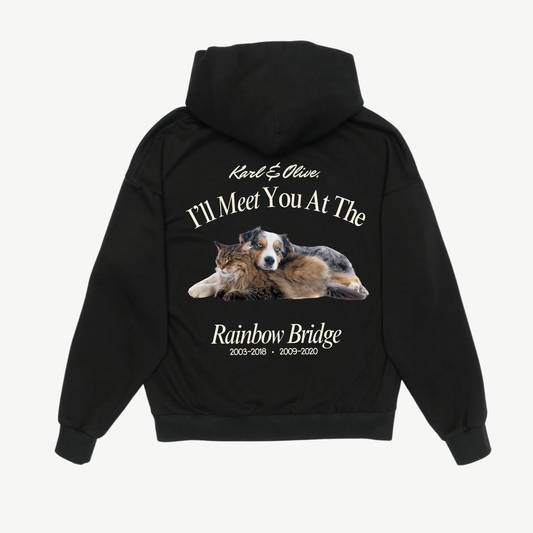 Back of a black hoodie with a dog and cat portrait and cream “I’ll meet you at the Rainbow Bridge” memorial lettering.